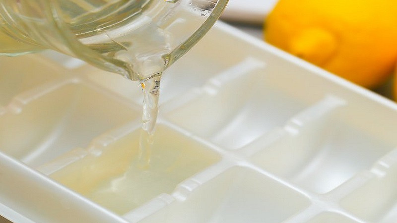 alt: Chanh tươi và khay đá đã chuẩn bị sẵn sàng để làm đá chanh