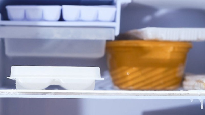 alt: Khay đá chứa nước cốt chanh tươi được đặt trong ngăn đá tủ lạnh